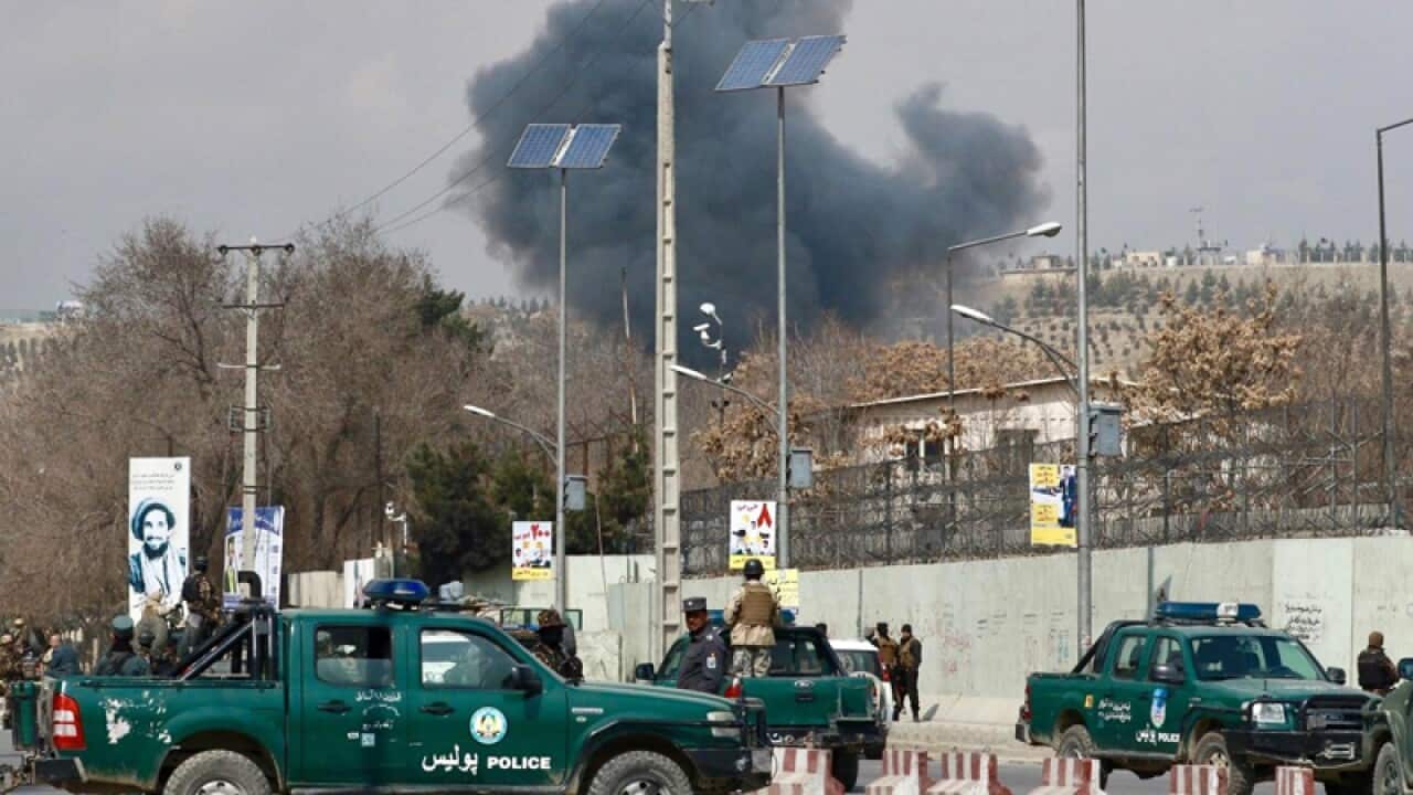 Security forces guard the area as smoke billows from a Kabul hospital