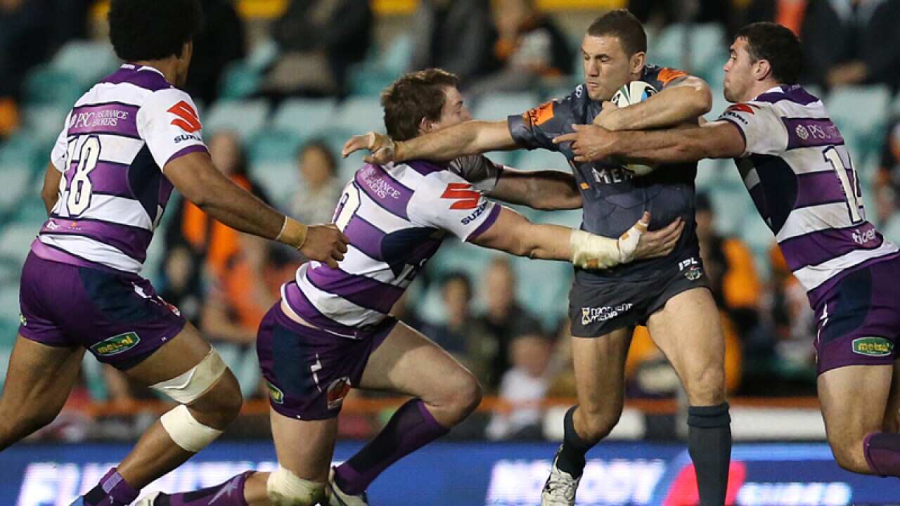 Melbourne Storm players tackle Wests Tigers' Robbie Farah