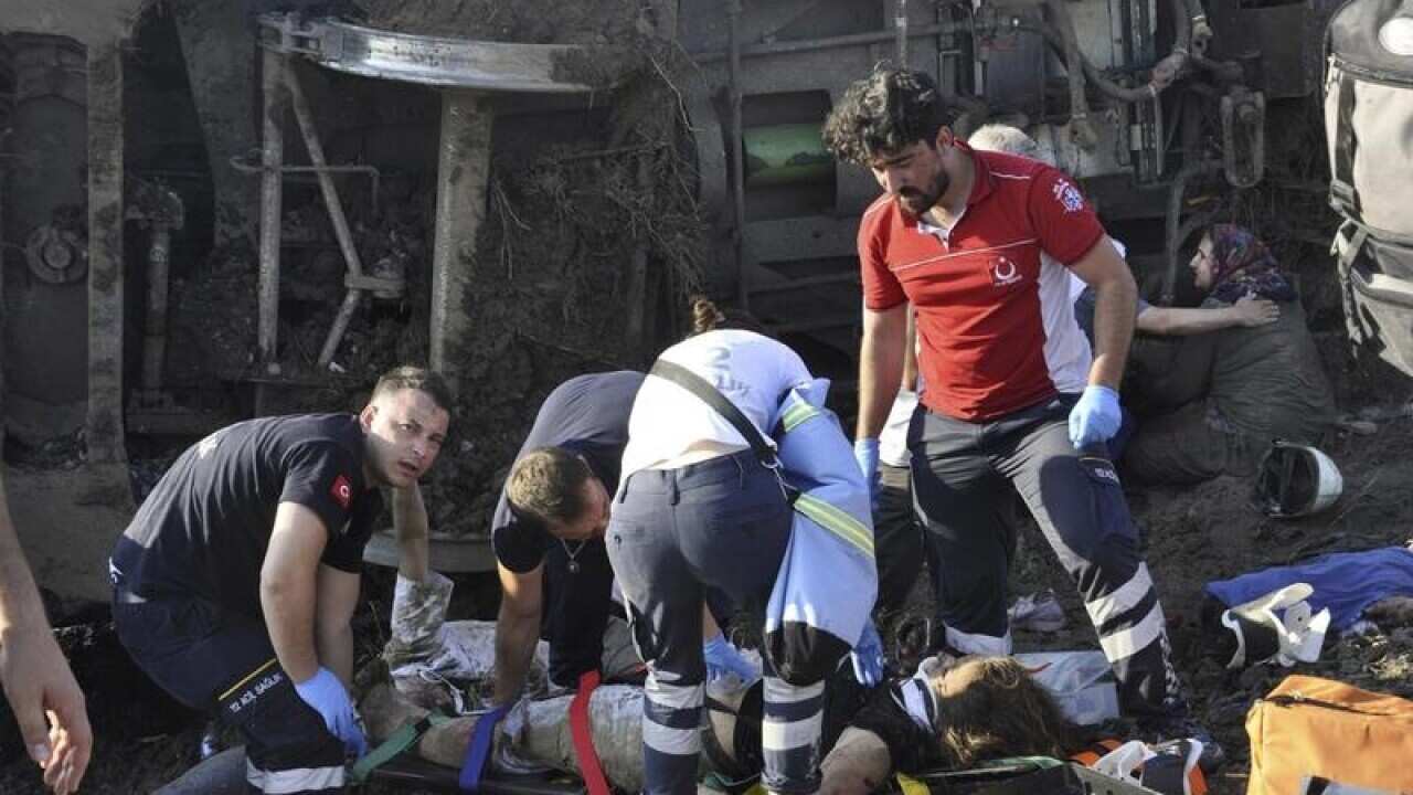 Emergency workers help victims among the overturned rail cars