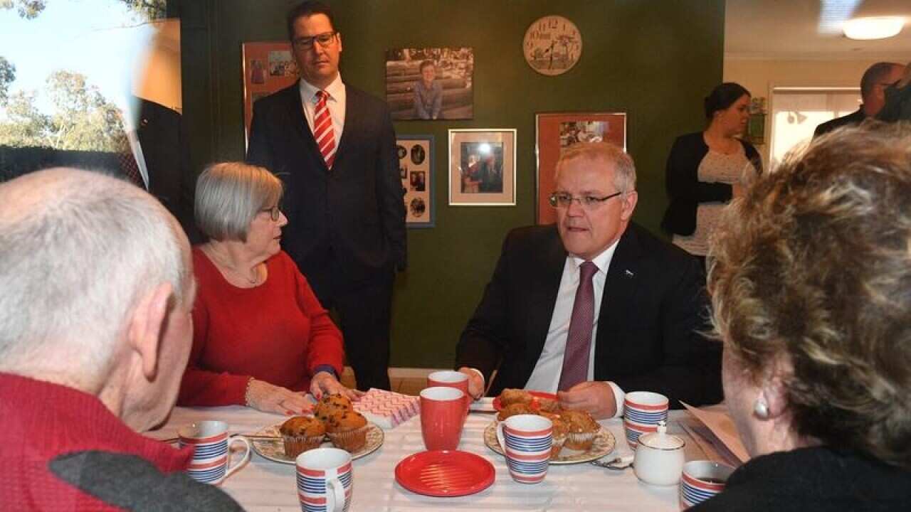 A file image of PM Scott Morrison visiting an elderly couple