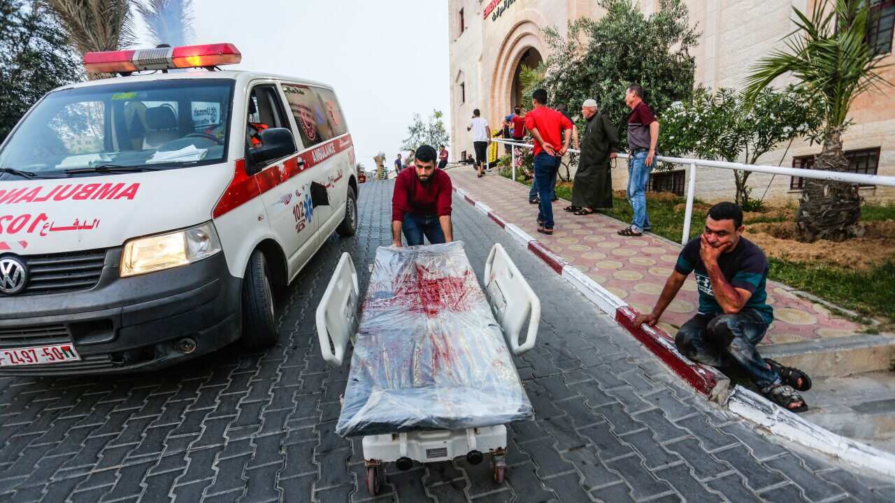 A Palestinian response worker pulls a stretcher bed covered with blood from victims of the Israeli-Palestinian violence in the northern Gaza Strip.