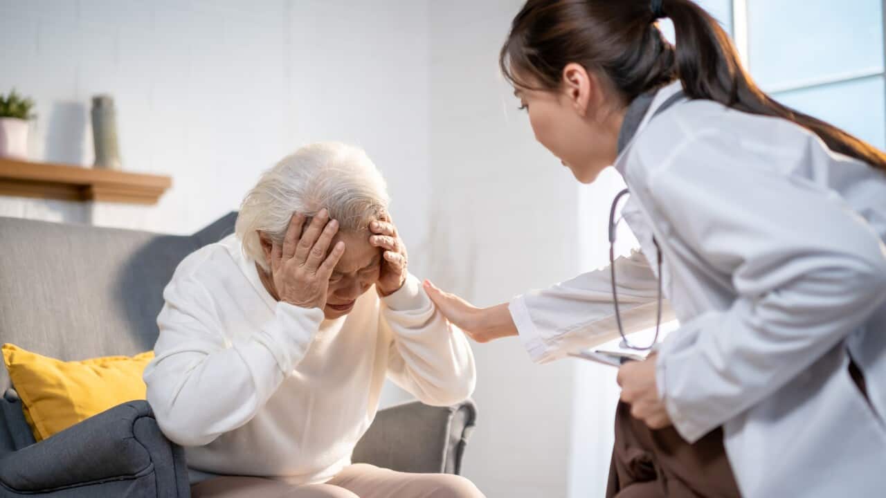 Asian caregiver nurse examine and listen to senior stress woman patient. Attractive specialist carer women support give advise and consult with older elderly mature grandmother in living room in house