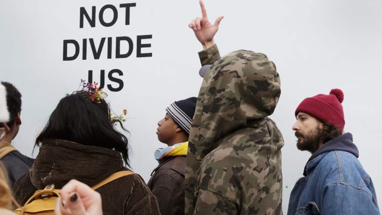 Shia LaBeouf (R) stands in front of his art installation