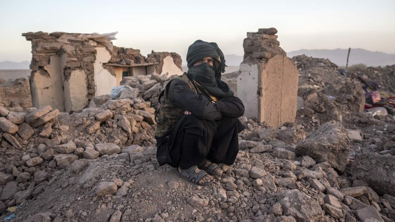 An Afghan sits by the rubble of his house following the quake (AAP)