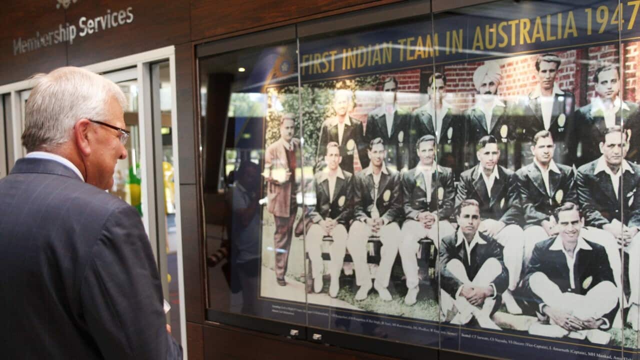 International Cricket Council (ICC) chief executive Malcolm Speed (L) inspects a picture of the first Indian team to tour Australia in 1947
