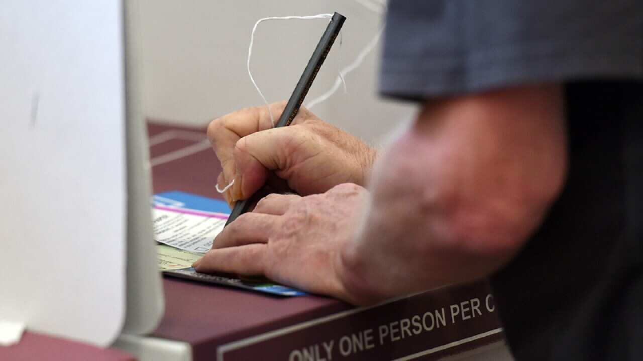 A voter makes his selection at a polling booth in Brisbane