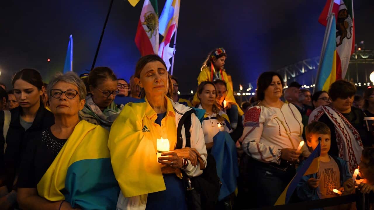 Ukrainian supporters gather outside the Sydney Opera House as the sails of the building are lit up in the colours of the Ukrainian national flag in Sydney on 1 March 2022.