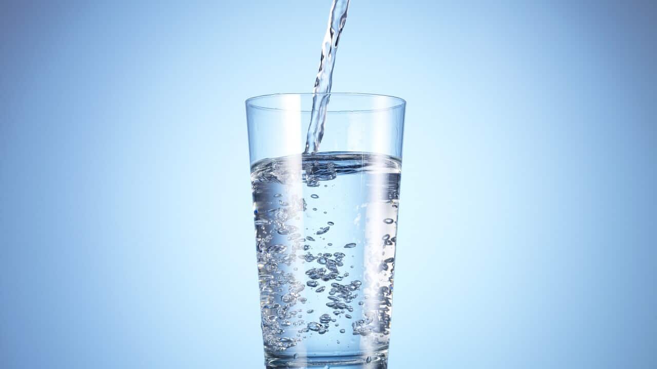 Cold drink water being poured into glass