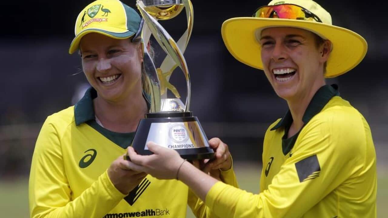Australian captain Meg Lanning (L) and Elyse Villani hold the trophy