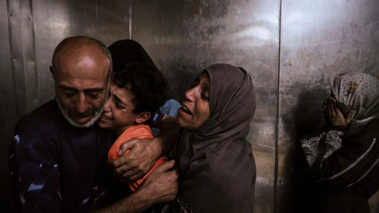 Raed Salem Aslyieh, left, from Jabaliya, hugs his relatives after the death of his son, Ahmed Raed Aslyieh, 18, who succumbed to injuries sustained in an Israeli strike that killed eight other family members four months earlier, worsened by a lack of proper treatment due to medicine shortages, at the morgue of Shifa Hospital in Gaza City