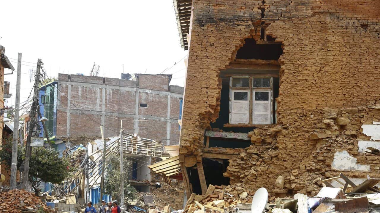 On 13 May 2015, people walk amidst collapsed houses while evacuating Chautara village, Sindhupalchwok district, a day after another powerful earthquake struck Nepal.