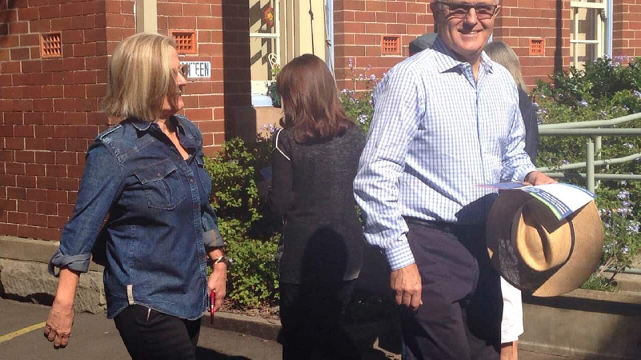 Communications Minister Malcolm Turnbull (R) votes in the NSW election