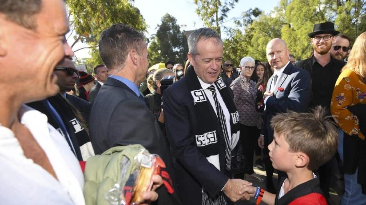 Bill Shorten speaks to a young Essendon fan before the Anzac Day game.