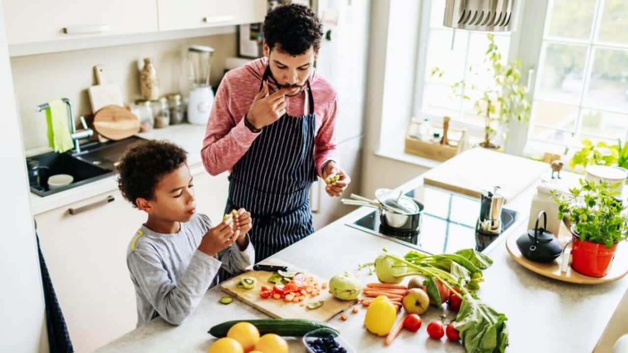 یک پدر و پسر در آشپزخانه در حال تهیه غذا