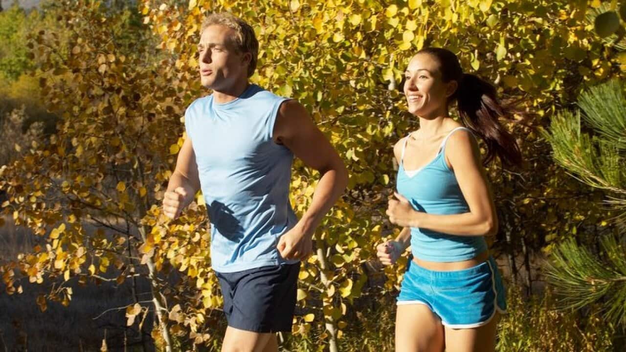 Couple jogging through woodland