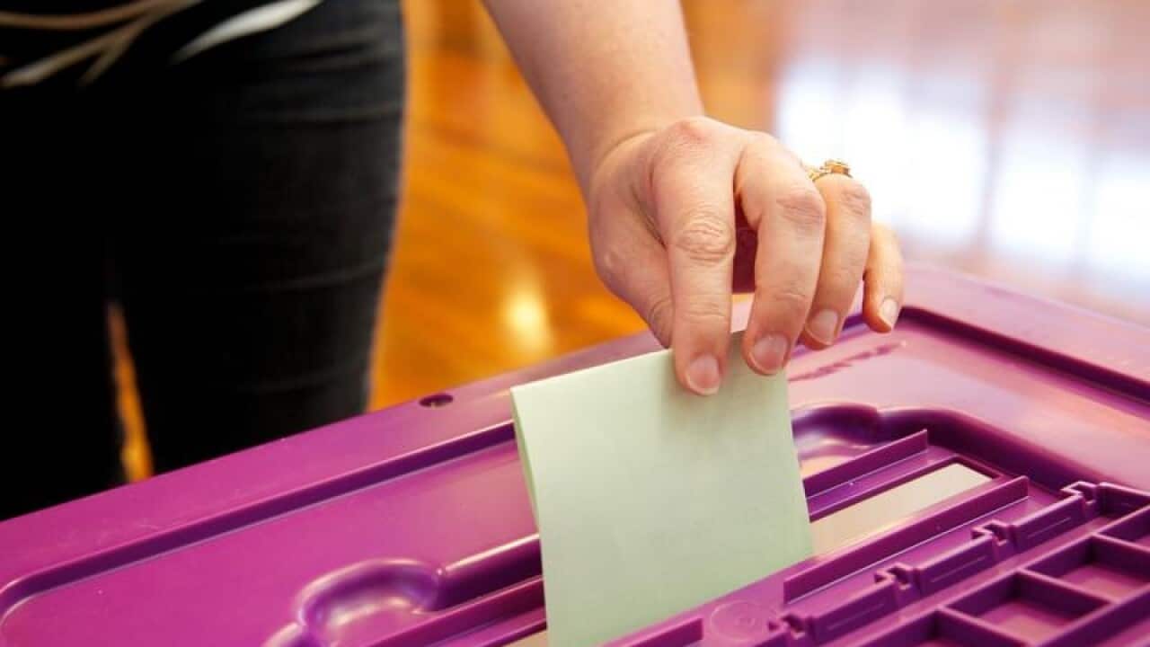A file image of a voter posting their ballot in a by-election