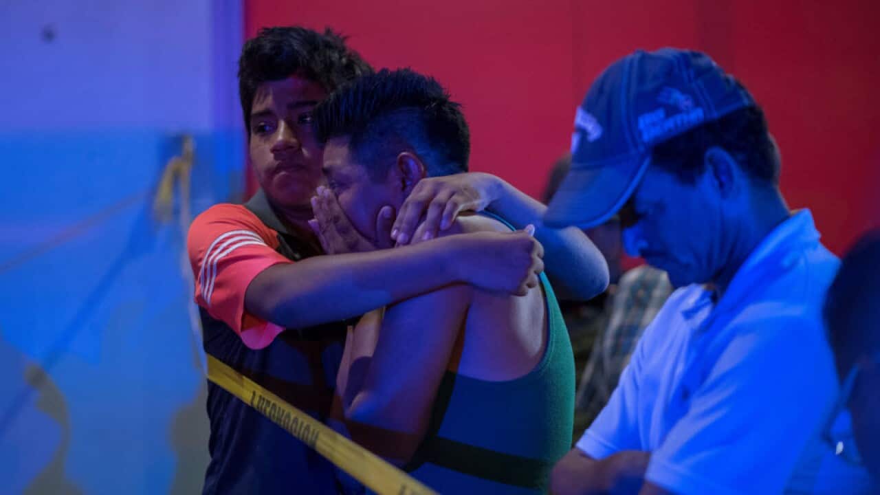 Relatives of victims react as they wait for news at the entrance to the bar 'Caballo Blanco' after an attack in Cotzacoalcos
