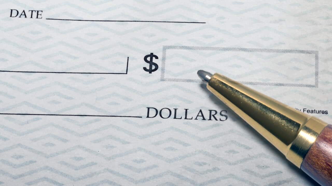A close up of a pen on top of a cheque.