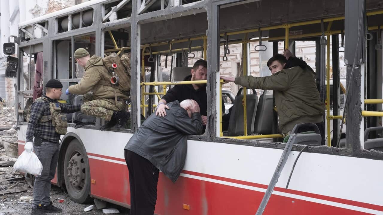 A man cries as he leans on the bus that was hit by a Russian missile on Sumy, Ukraine