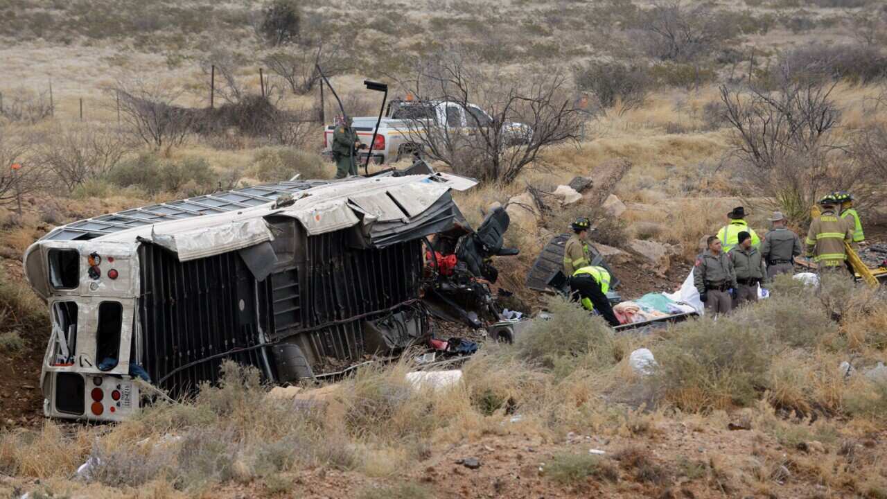Officials investigate the scene of a prison transport bus crash in Penwell, Texas