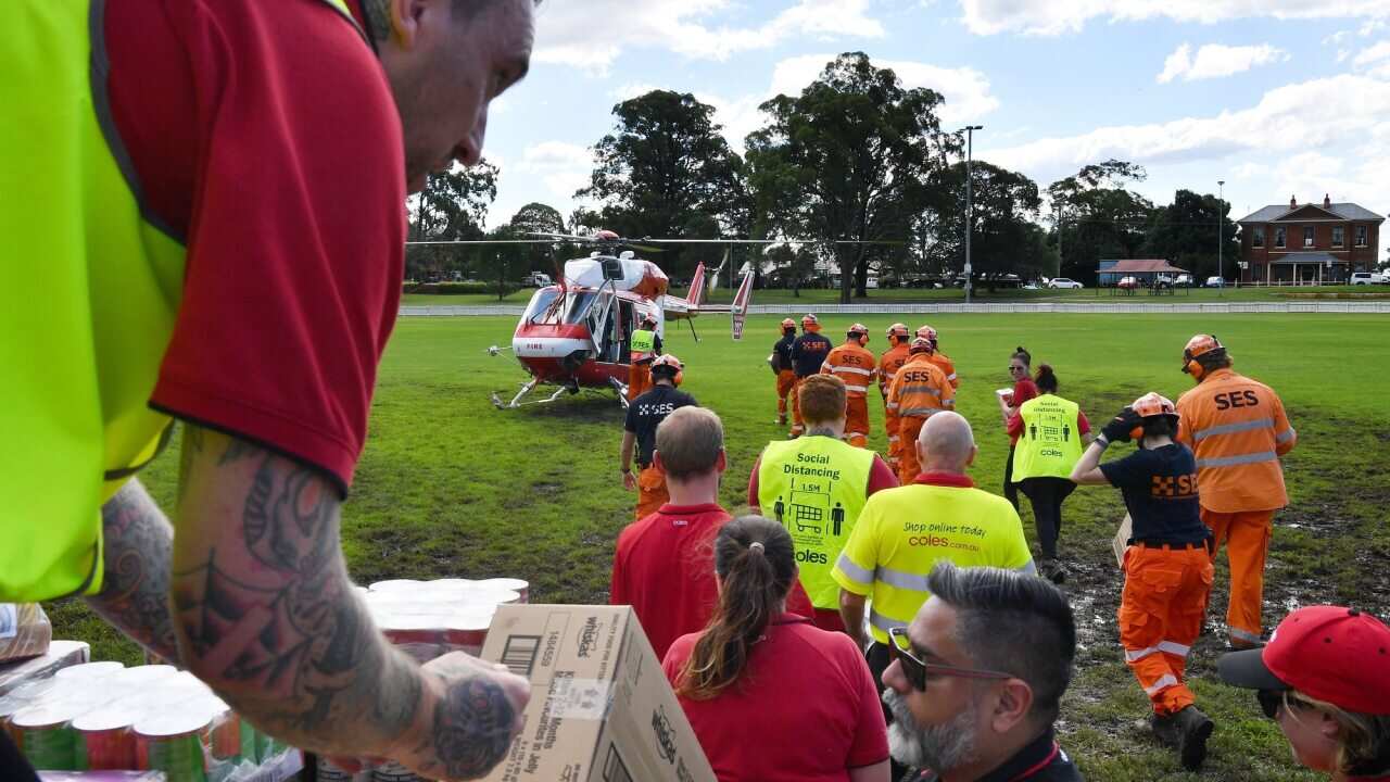 SES volunteers load food and essential items onto a rescue helicopter at Windsor to be deployed to North Richmond and other areas cut off by floodwaters.