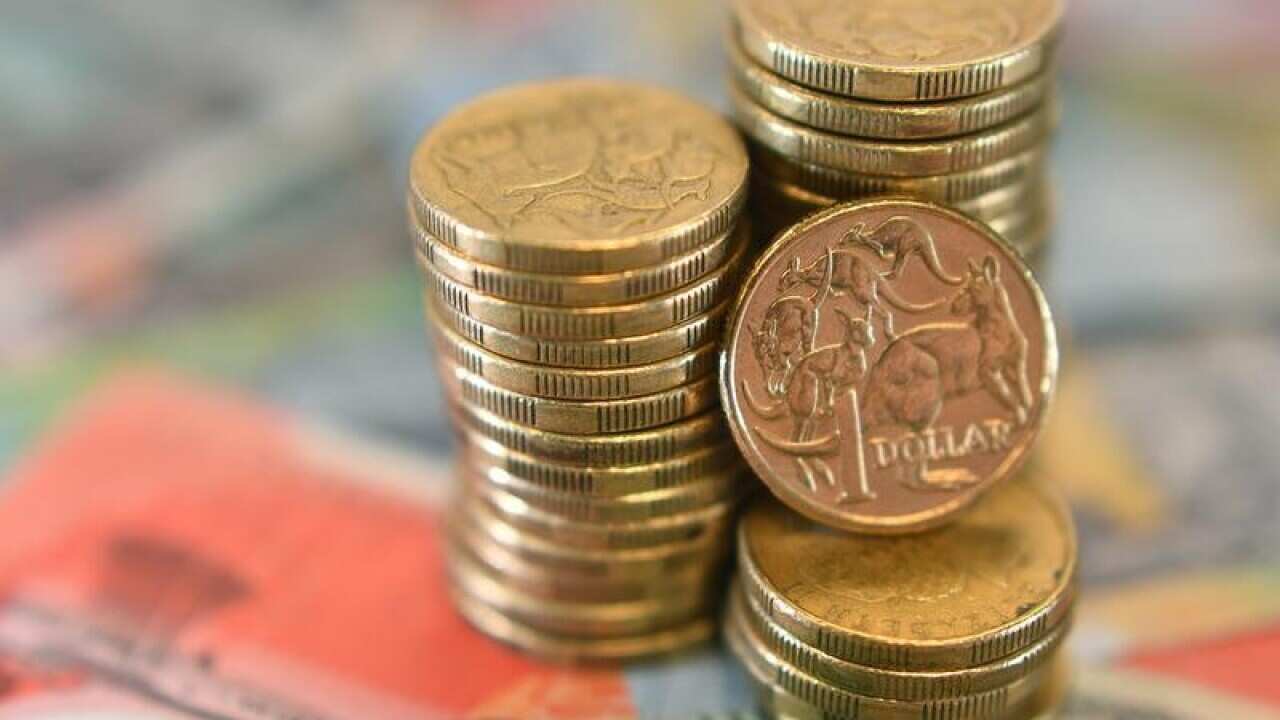 A close up of Australian dollars on top of a $20 note.