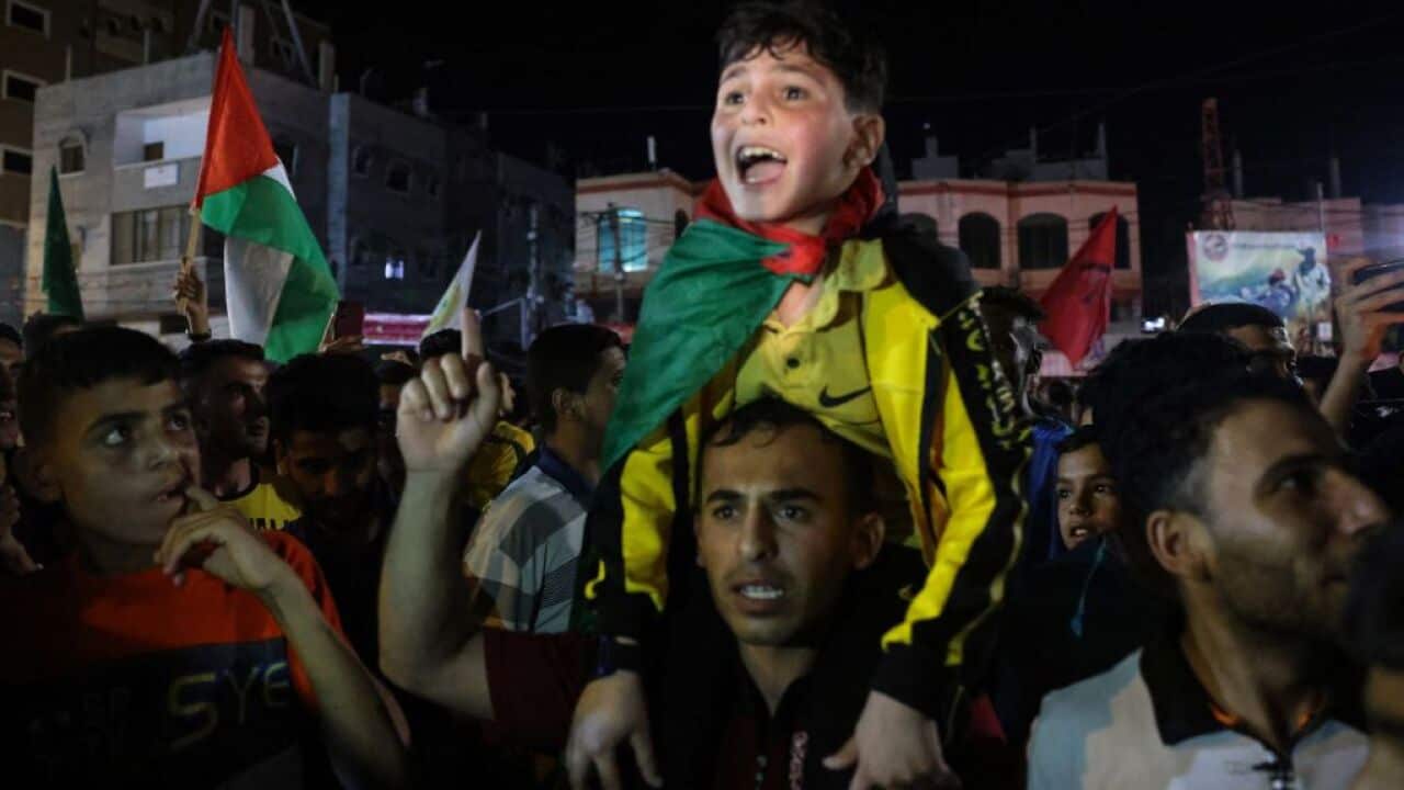 People gather on the street as they celebrate the ceasefire brokered by Egypt between Israel and the two main Palestinian armed groups in Gaza.