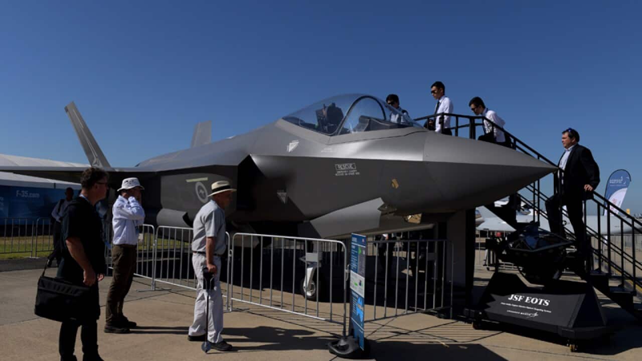 Visitors look at a F-35 Joint Strike Fighter