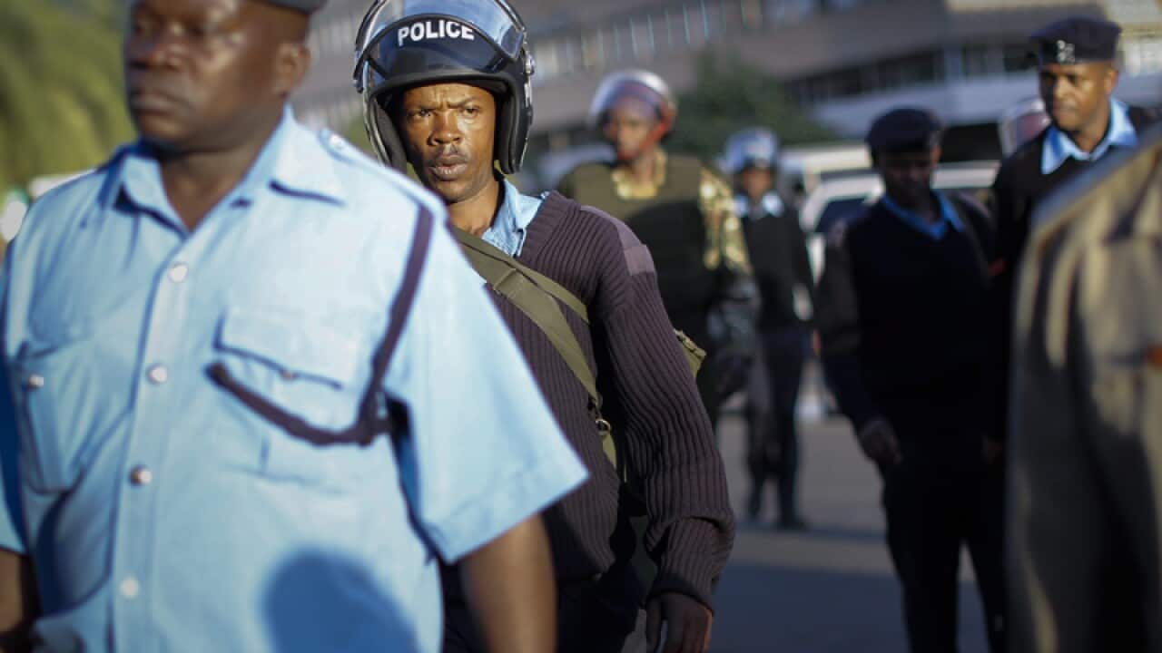 Police officers walk into Kenya's parliament building.