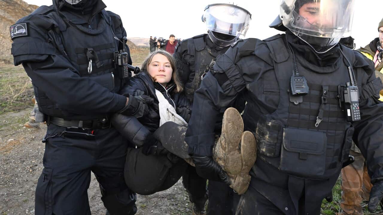 A woman being carried by police officers