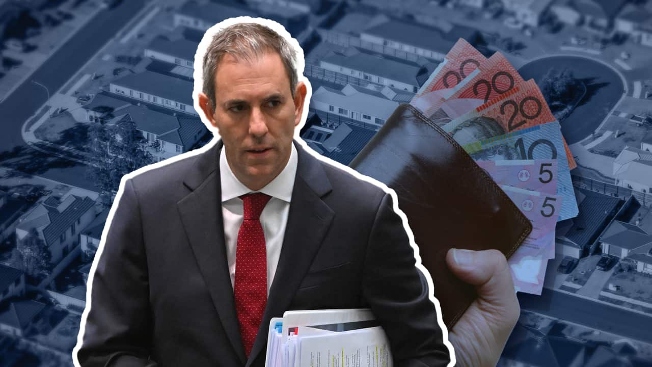 A man in a suit, holding paperwork under his arm.