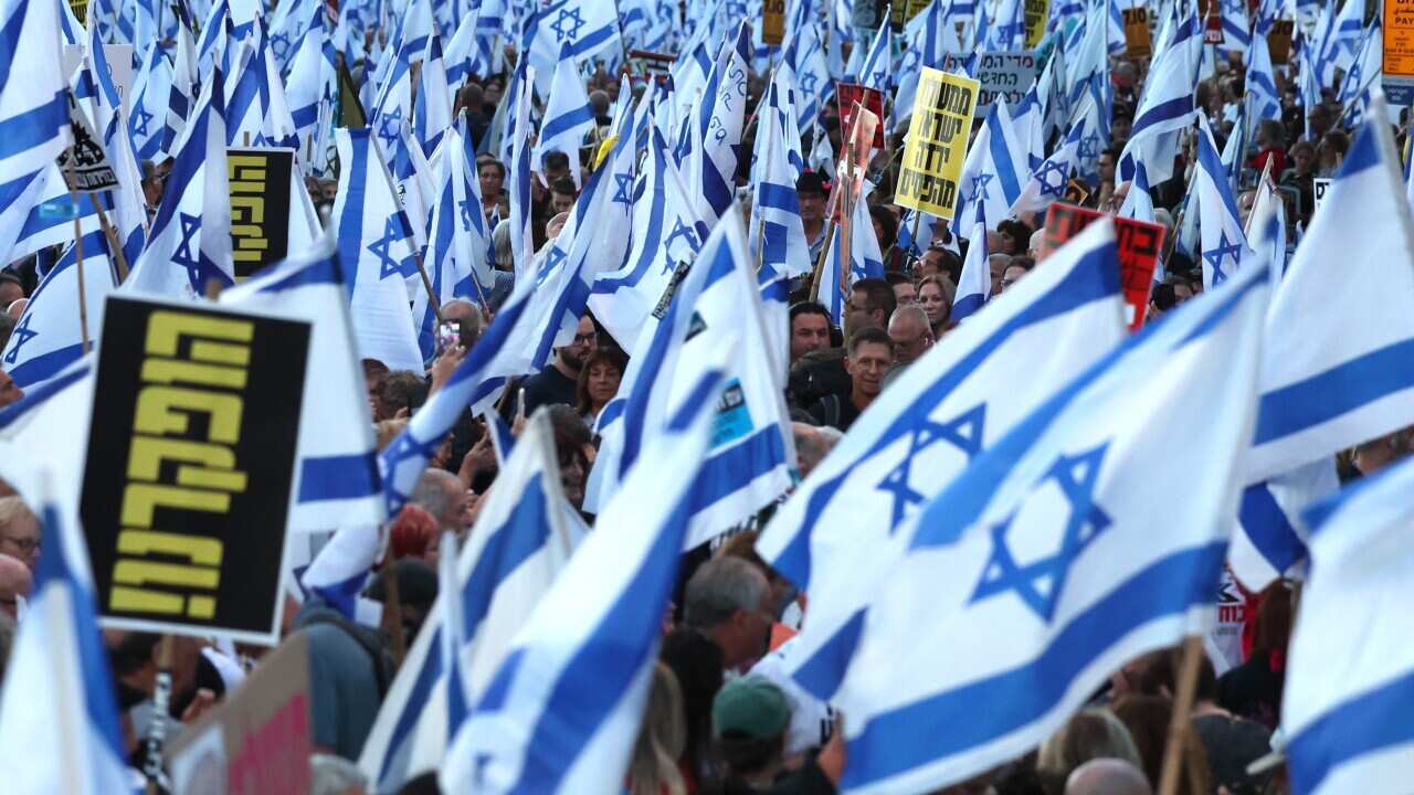 Anti-government protesters hold Israeli flags and placards during a rally calling for the release of hostages held by Hamas and the Israeli prime minister's resignation outside the Knesset, the Israeli parliament, in Jerusalem, 31 March 2024.