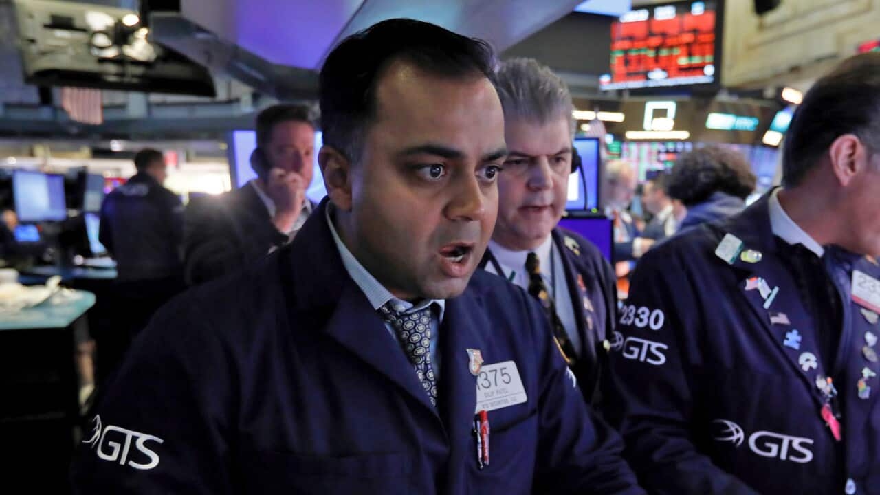 Specialist Dilip Patel reacts while working at his post at the New York Stock Exchange