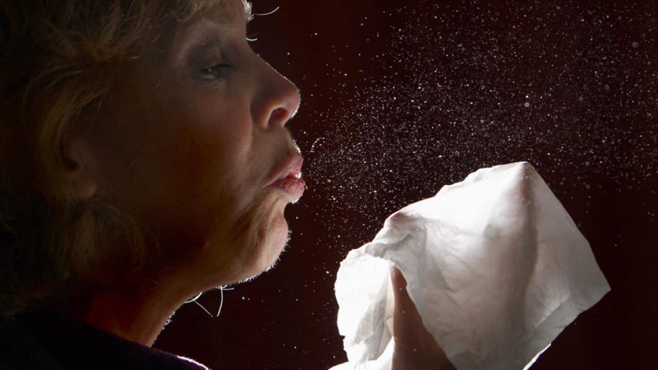 A woman sneezes
