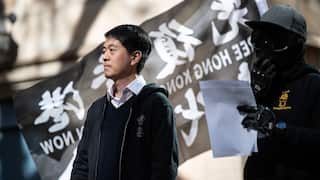 A man stands at a rally with police around him