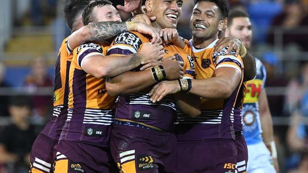 Joe Ofahengaue of the Broncos (c) celebrates after scoring a try