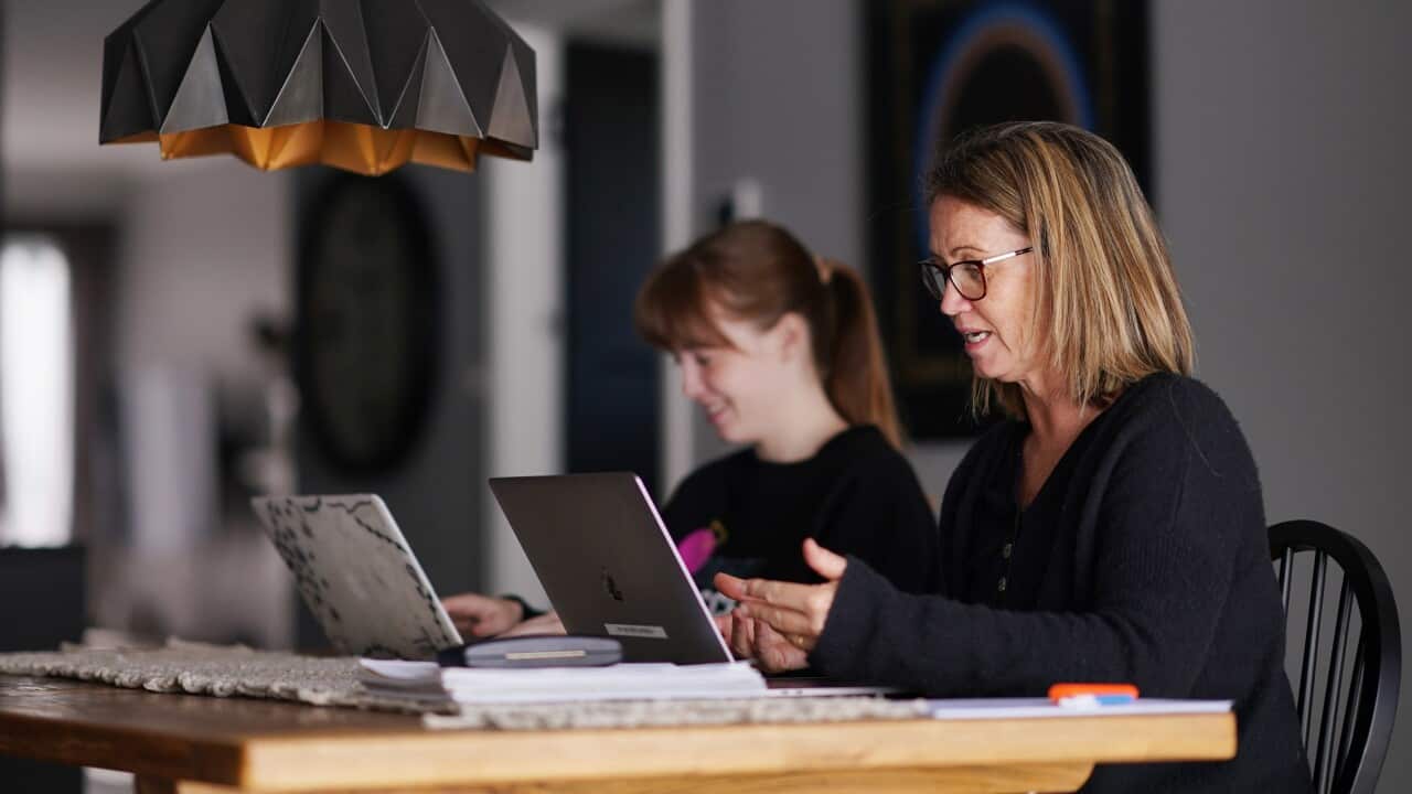 Secondary student Lauren, from Bayside Secondary school, takes part in her online school class as her mother Gayle, a teacher from Flinders Christian College, takes students for online schooling in Melbourne, Wednesday, April 15, 2020. Most students and