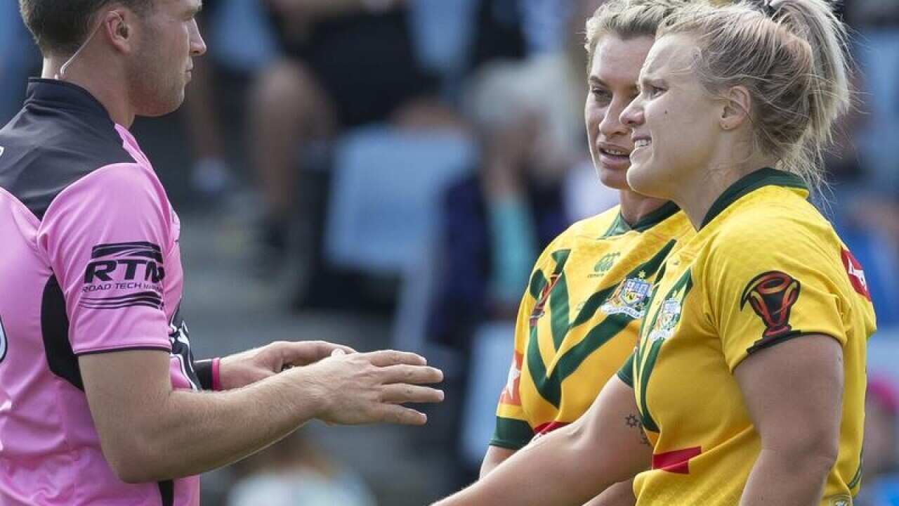Renae Kunst of Australia shows her arm to officials