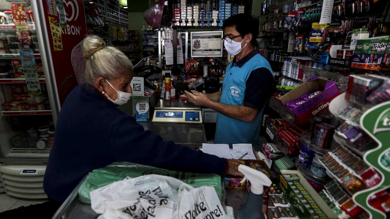 Merchant and client make use of protective masks in a Sao Paolo store