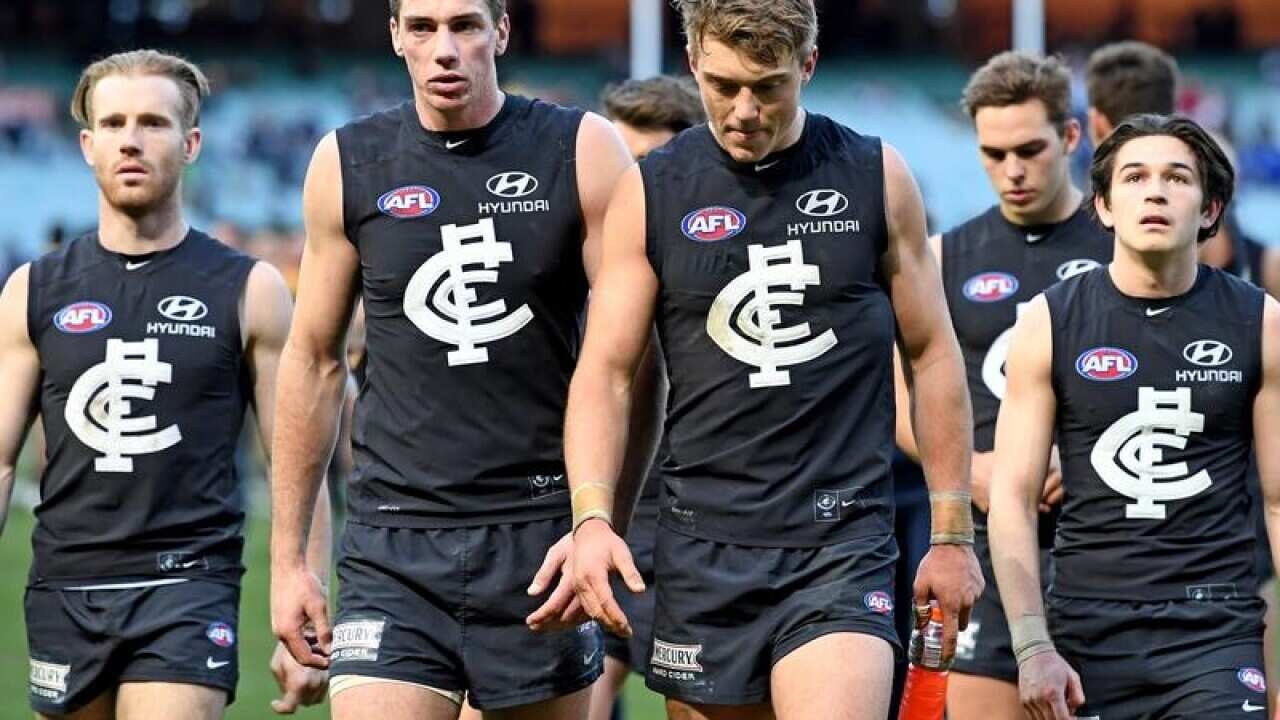 Carlton players walk off the ground