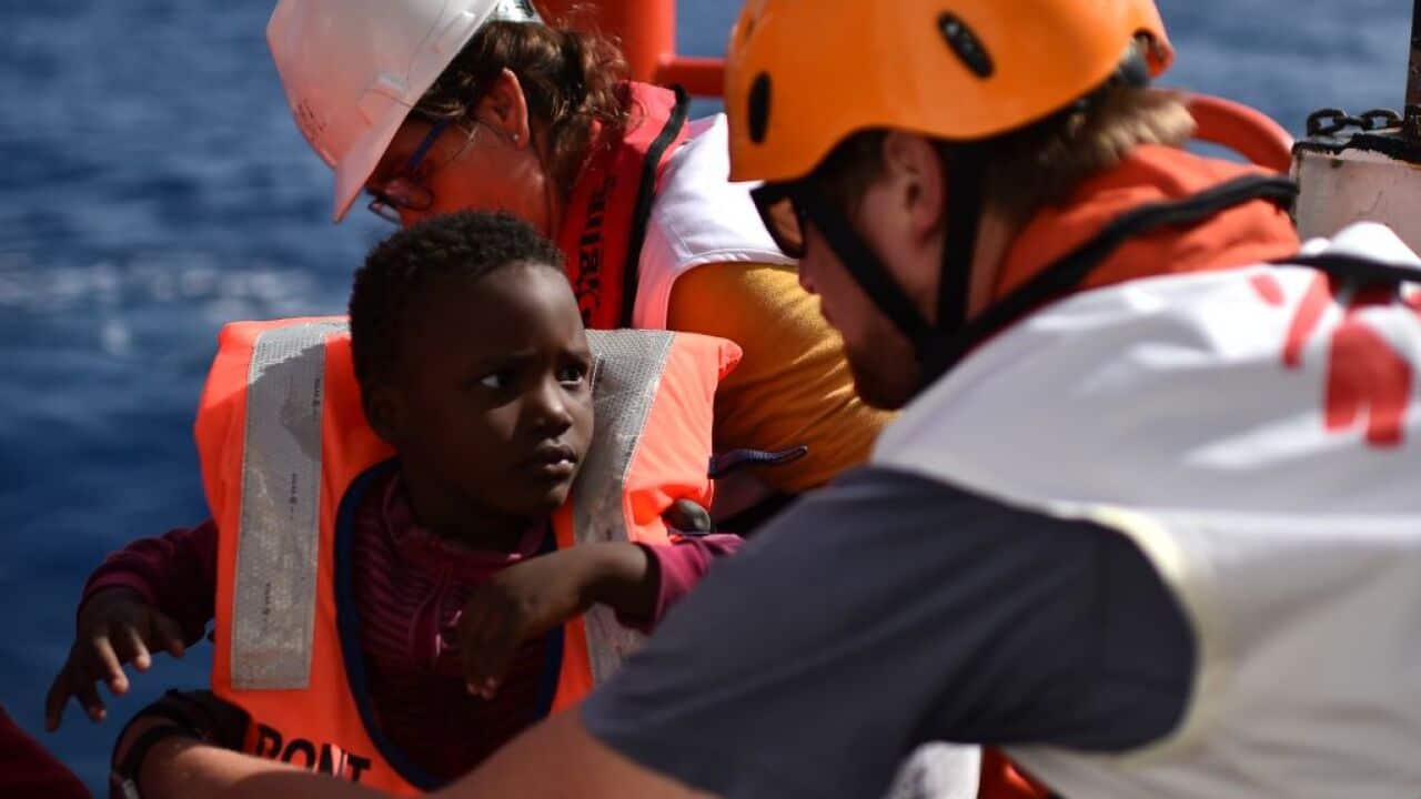 Rescuers take care of a child during a rescue operation at sea of migrants and refugees with the Aquarius ship in 2016.