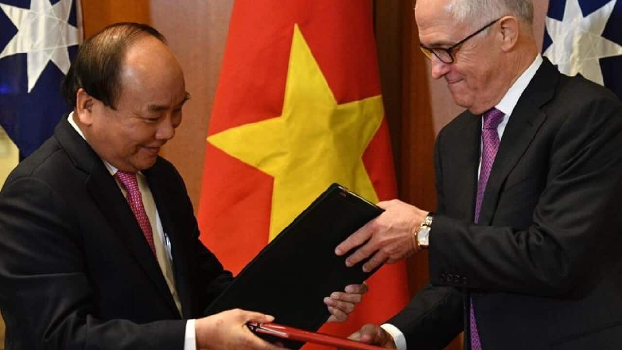 Vietnam's PM Nguyen Xuan Phuc and Malcolm Turnbull exchange papers.