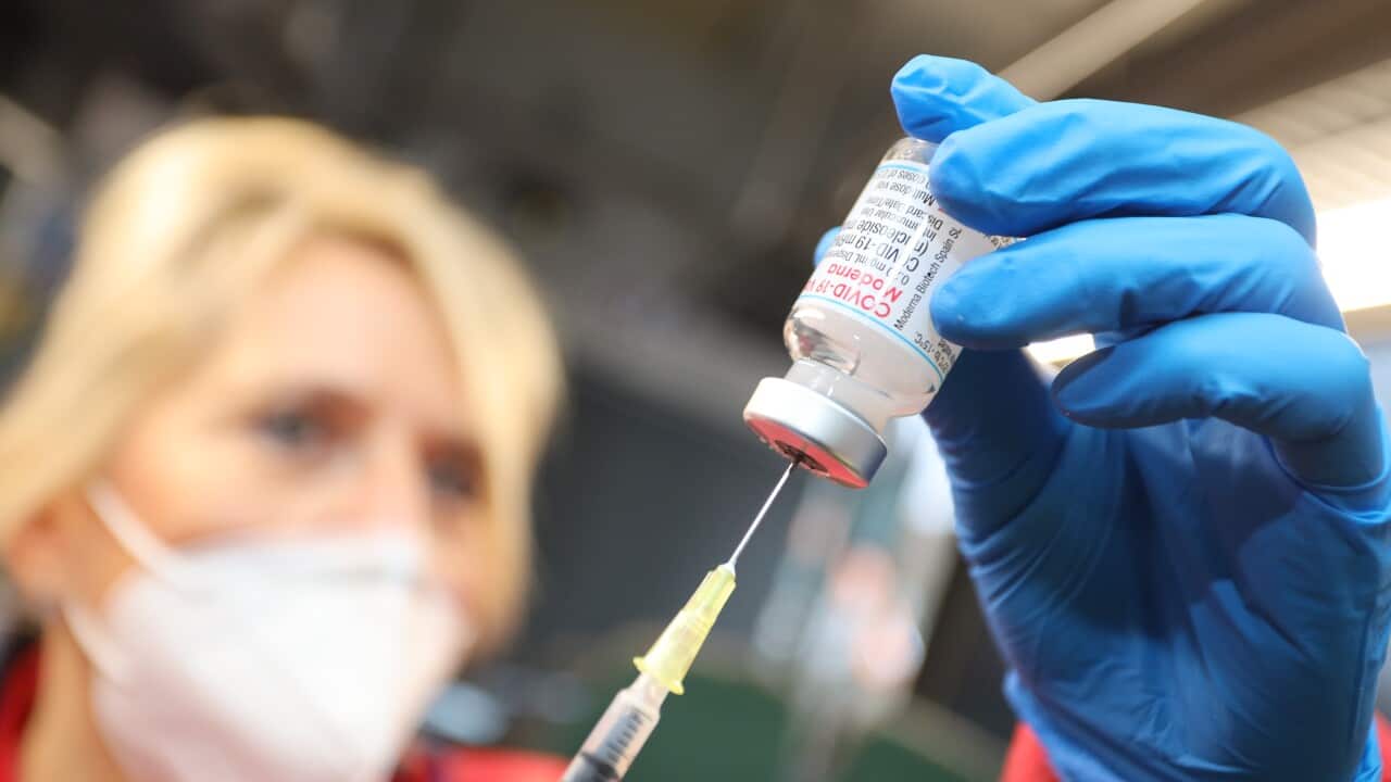 A nurse prepares a COVID-19 vaccine. 