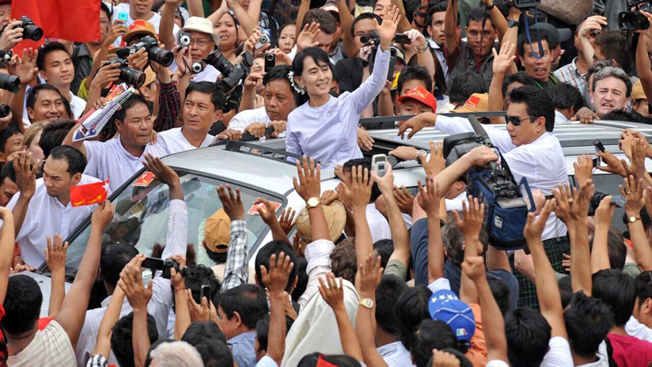 Burma opposition leader Aung San Suu Kyi waves to supporters as she leaves National League for Democracy headquarters after securing a parliamentary seat in historic by-elections. (Getty Images)
