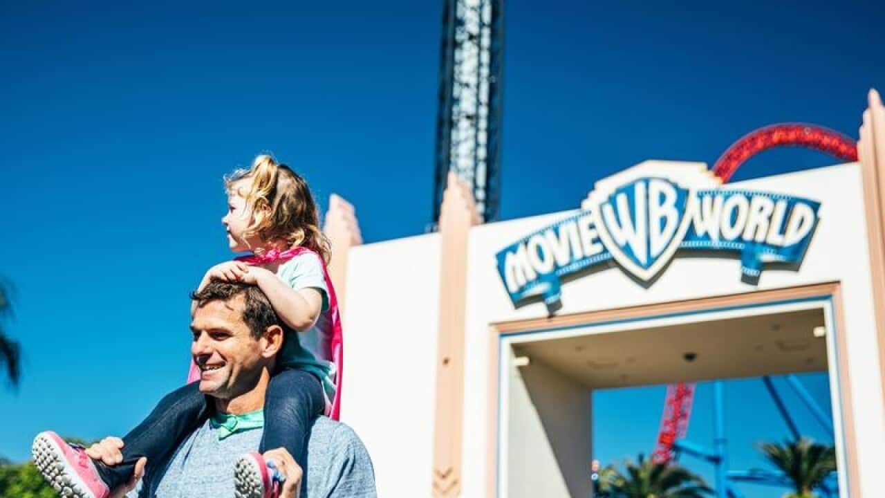 A father with his daughter outside Movie World on the Gold Coast