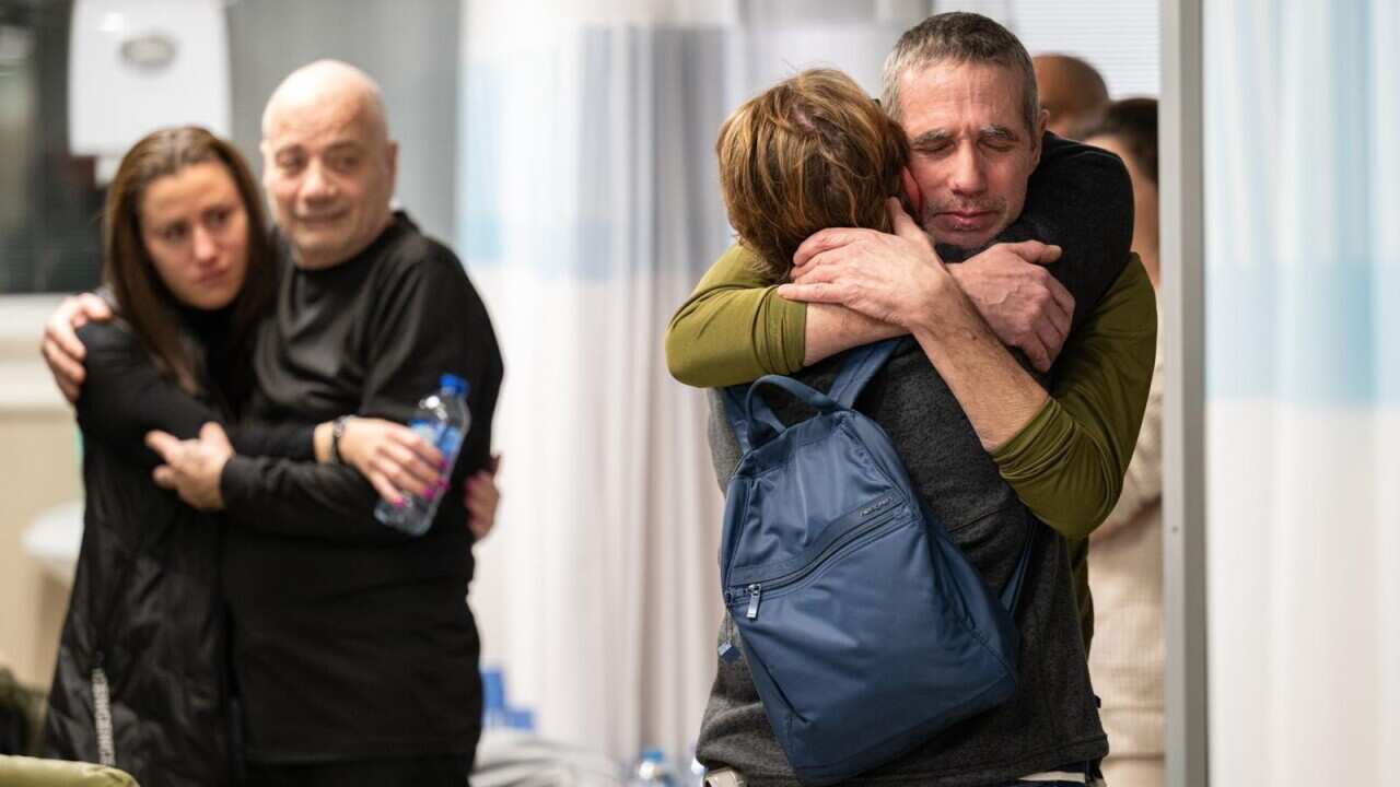 A released hostage hugs someone in an airport