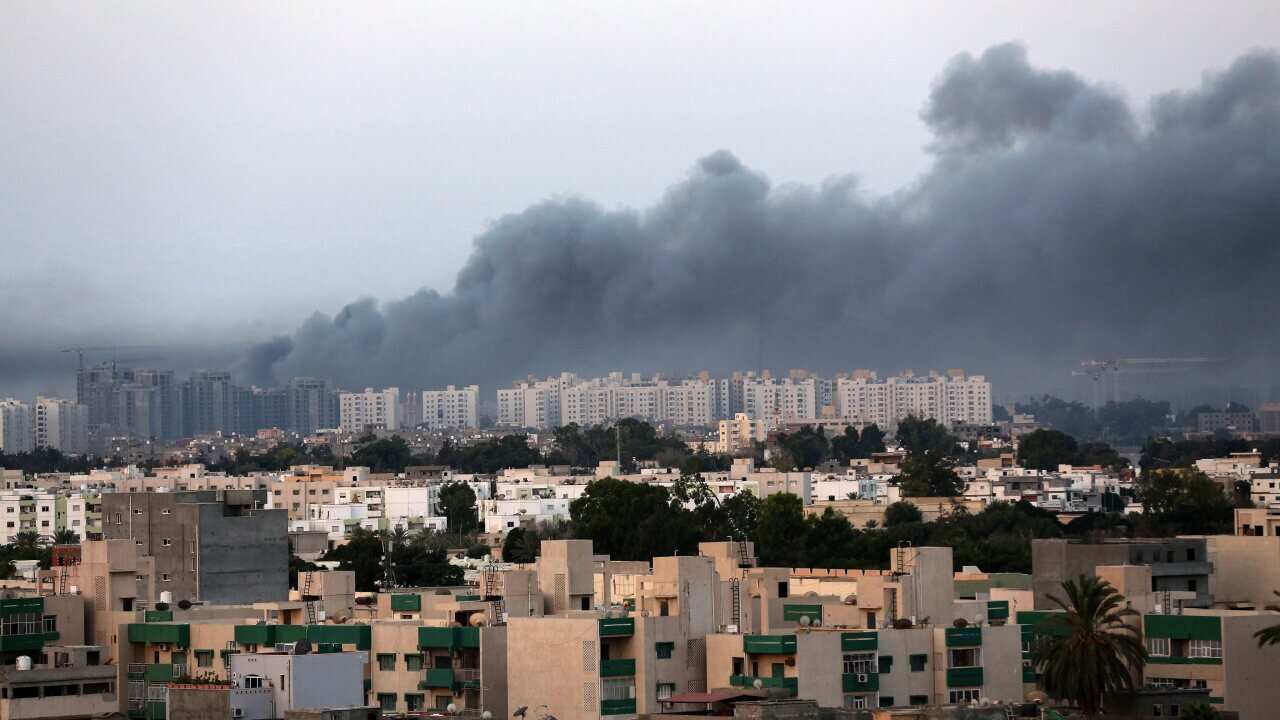 Smoke billows from buildings during clashes between Libyan security forces and armed Islamist groups in the eastern coastal city of Benghazi on August 23, 2014.