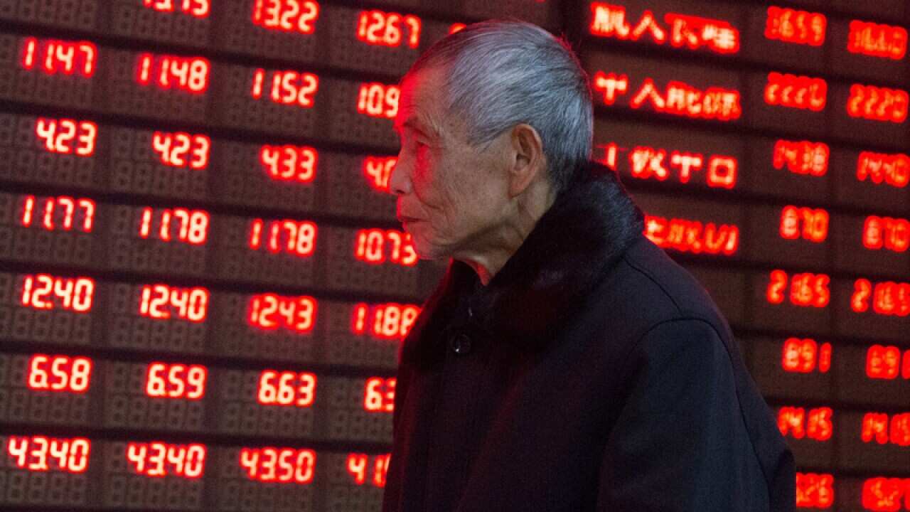 A Chinese investor looks at prices of shares