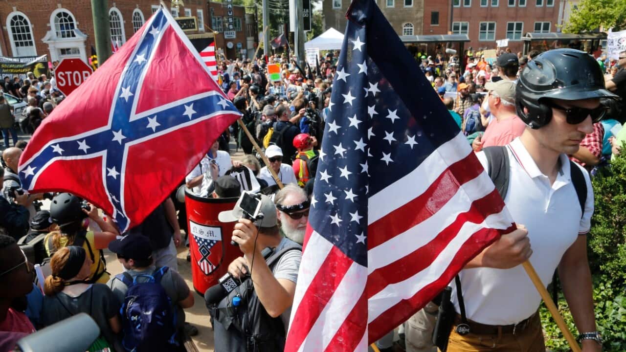 White nationalist demonstrators walk into Lee park surrounded by counter demonstrators in Charlottesville, Va., Saturday, Aug. 12, 2017. 