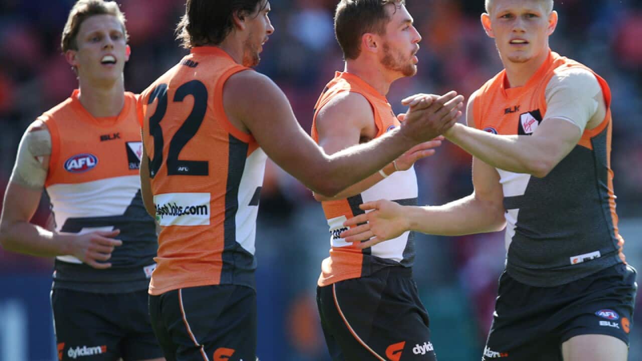 GWS players celebrate after kicking a goal